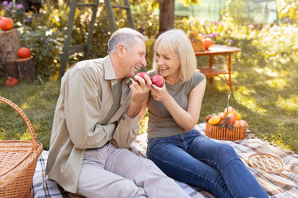 Older couple eating comfortably outdoors after restorative treatment