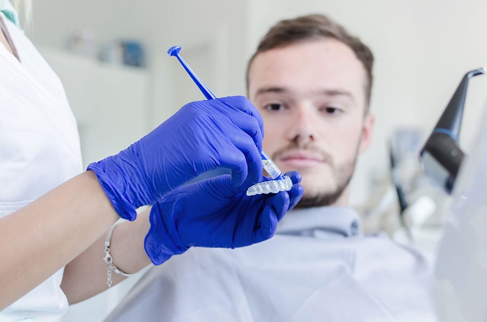 Dentist applying a professional whitening treatment