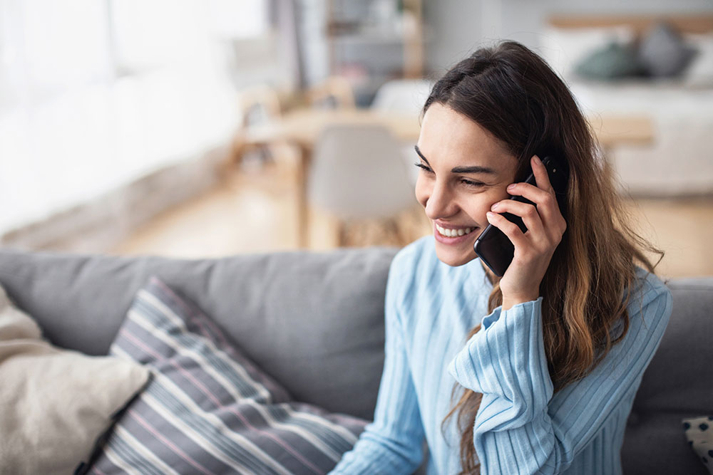 Woman smiling on the phone at home