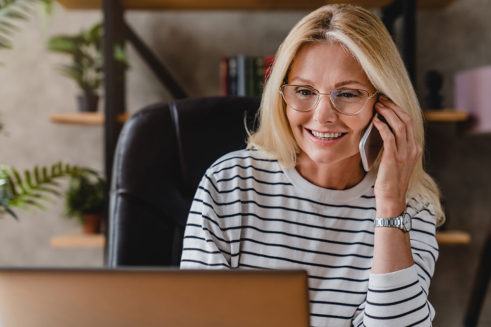 Woman booking a dental appointment by phone