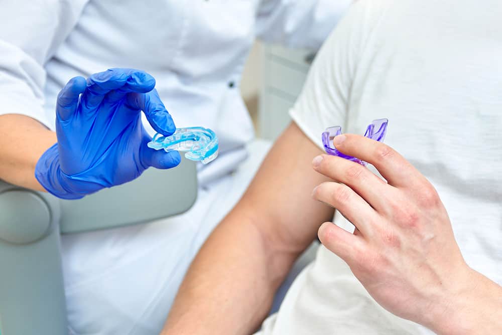 Dentist fitting a custom mouthguard