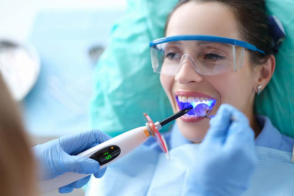 Patient receiving treatment under a dental curing light