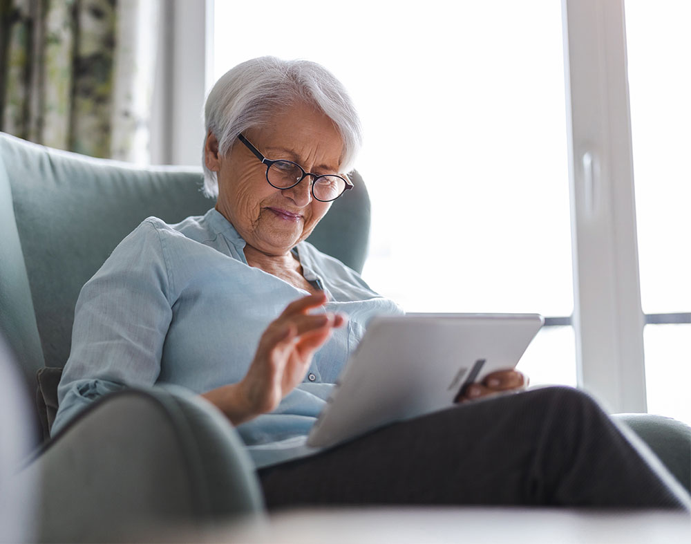 Older woman comfortably reviewing her snap-on denture treatment plan at home