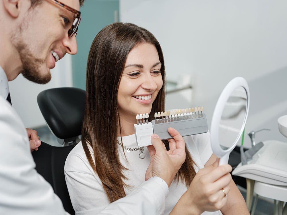 Dentist matching veneer shades with a patient