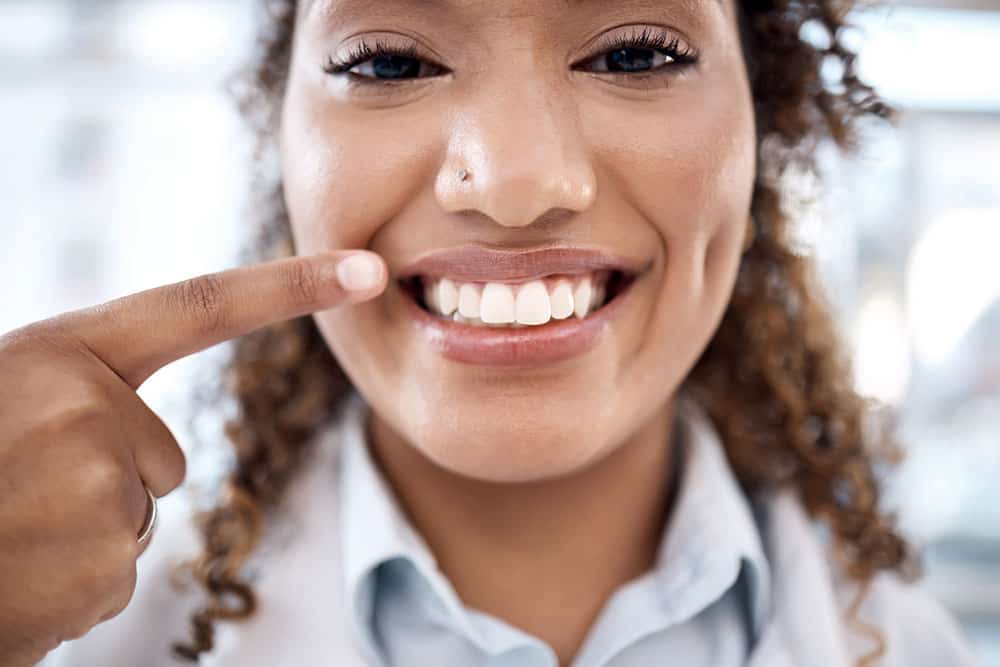 Woman pointing to her whitened smile