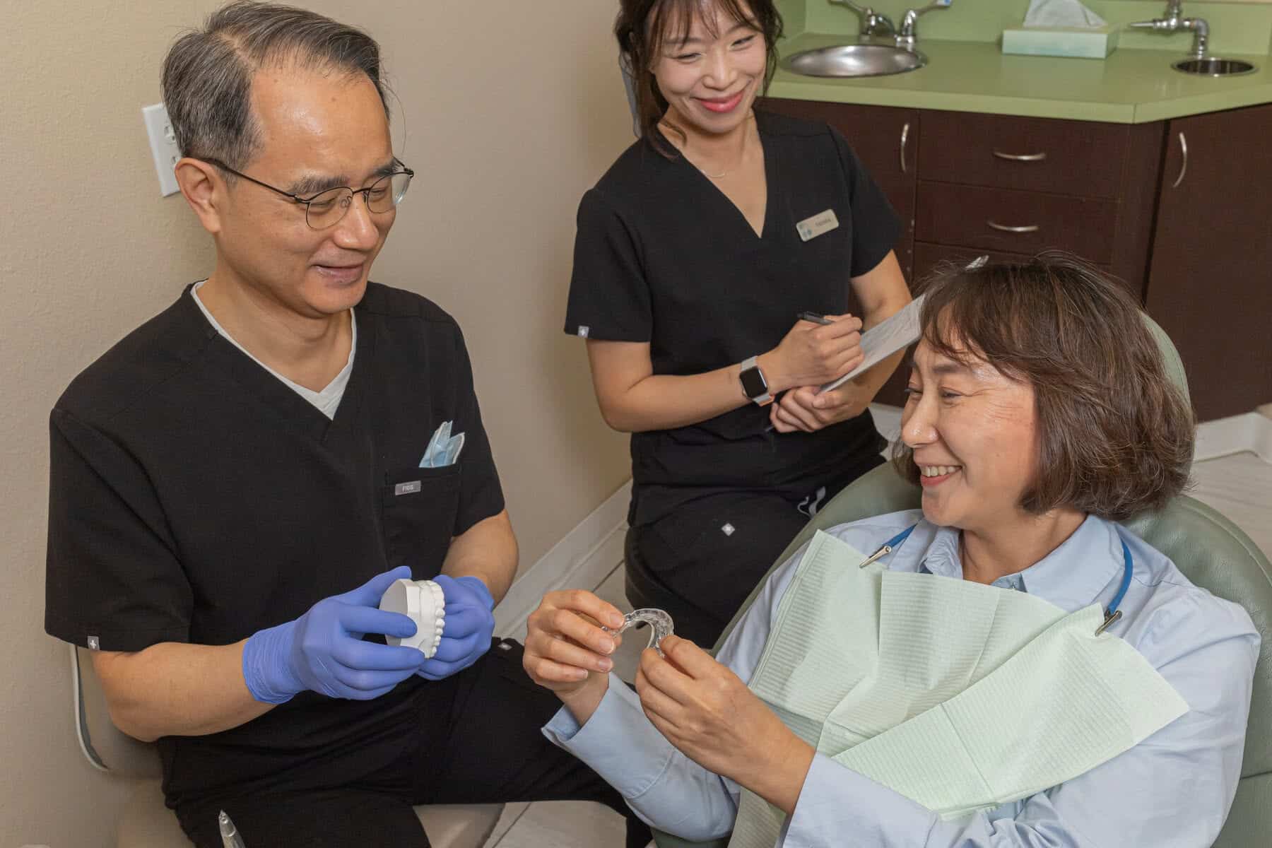 Dr. Yoon and a team member preparing a tooth for a dental crown