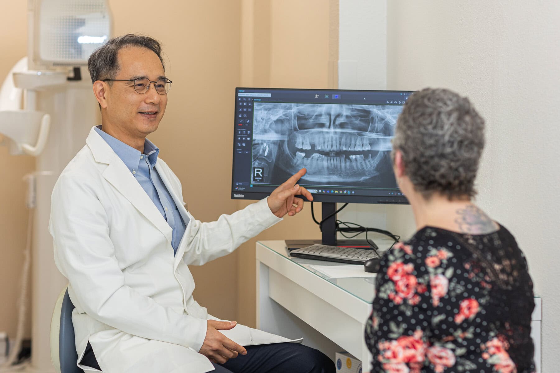 Dr. Yoon explaining an X-ray to a patient before removing a tooth