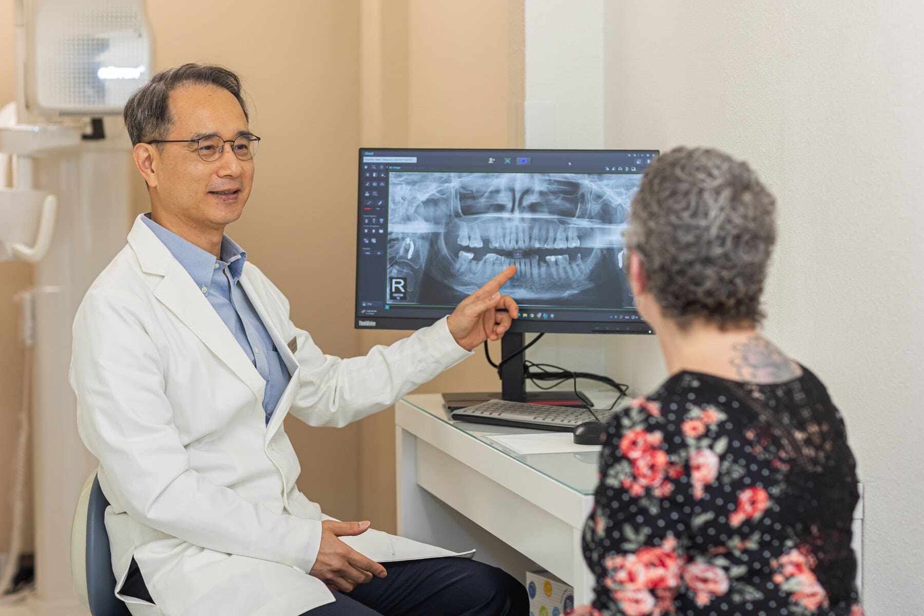 Dr. Yoon reviewing a panoramic X-ray with a patient